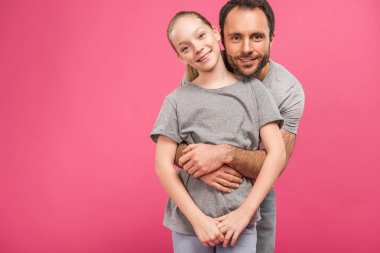 happy father hugging smiling daughter, isolated on pink clipart