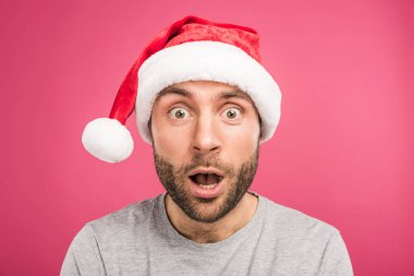 portrait of shocked man in santa hat, isolated on pink clipart