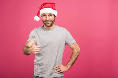 başparmak gösterilmesini, pink izole santa şapka içinde gülümseyen adam portresi 