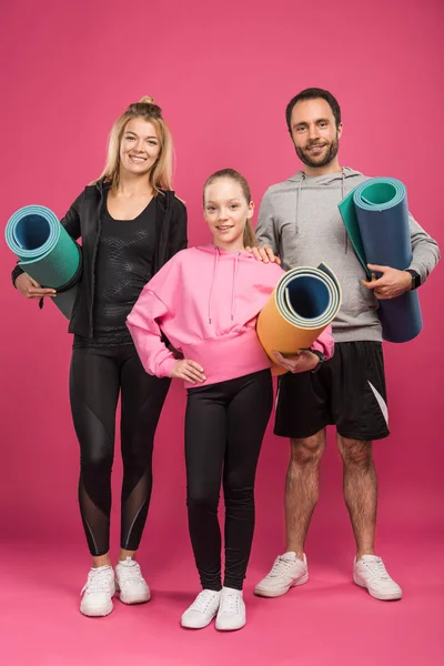 Γονείς Και Κόρη Αθλητικά Ρούχα Κρατώντας Χαλάκια Γυμναστικής Απομονώνονται Ροζ — Φωτογραφία Αρχείου