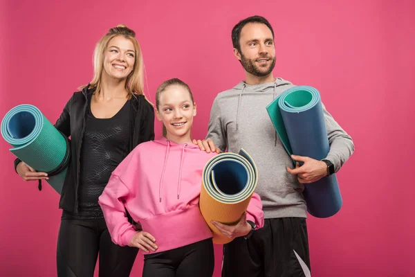 运动的家庭与女儿拿着健身垫 隔离在粉红色 — 图库照片