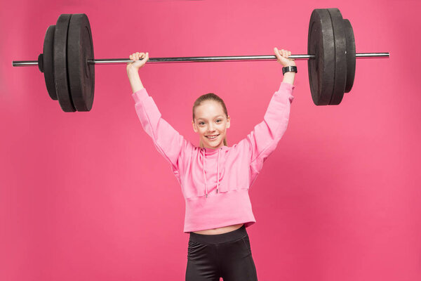 спортивная женщина-подросток работает с штангой, изолированы на розовый
