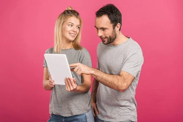 美丽的夫妇使用数字平板电脑 隔离在粉红色 — 图库照片