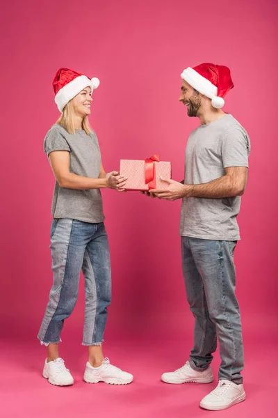Beautiful Happy Couple Santa Hats Gifting Christmas Present Pink — Free Stock Photo