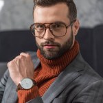 Portrét pohledný muže ve formálním oblečení a brýle při pohledu na fotoaparát