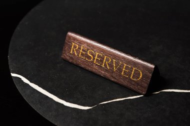 reserved sign on black table in cafe with copy space clipart
