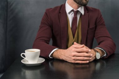 formal giyim ile Restoran kahve fincan masada oturan yakışıklı işadamı kırpılmış görünümünü