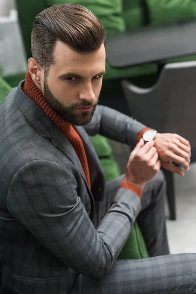 Man Formal Wear Sitting Green Sofa Adjusting Watch Hand — Stock Photo, Image