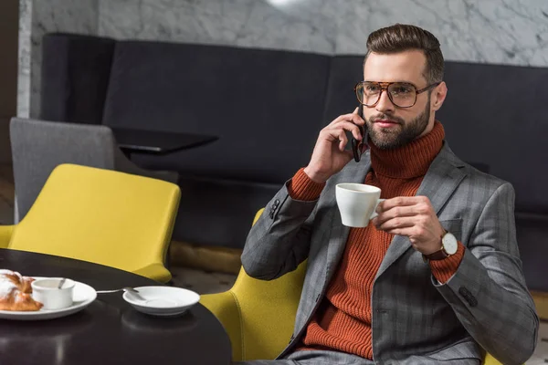 Allvarlig Stilig Man Formella Slitage Talar Smartphone Medan Dricka Kaffe — Stockfoto