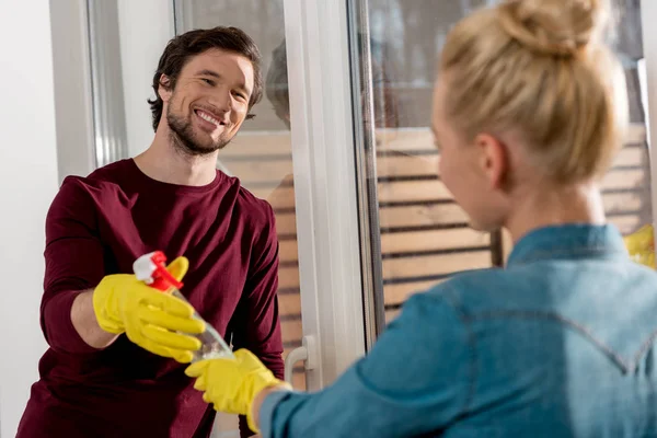 Meisje Rubber Handschoenen Geven Schoonmaak Spray Aan Glimlachende Man — Stockfoto