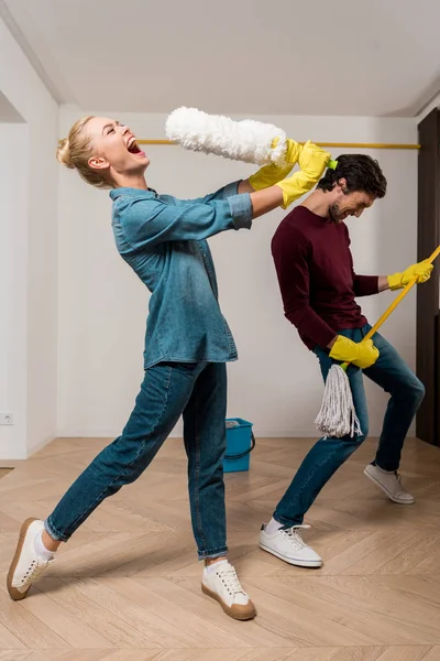 Happy Girl Rubber Gloves Singing Duster While Husband Performing Mop — Stock Photo, Image