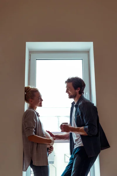 Happy Man Standing Window Touching Belly Pregnant Wife — Stock Photo, Image