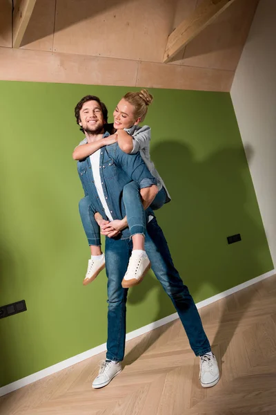 Smiling Man Giving Piggyback Ride Cheerful Girl Apartment — Free Stock Photo