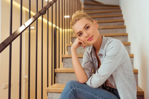 Schönes Mädchen Sitzt Auf Einer Treppe Und Schaut Die Kamera — kostenloses Stockfoto
