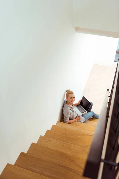 Красивая Девушка Сидящая Лестнице Используя Ноутбук Глядя Камеру — Бесплатное стоковое фото