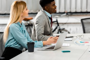 Afrika kökenli Amerikalı işadamı ve işyeri dizüstü bilgisayar ve ofis gazetelerde beyaz iş kadını