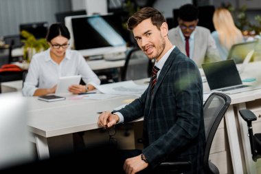 takım elbiseli genç işadamı ve ofiste çok ırklı arkadaşları seçici odak