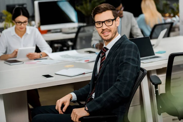 スーツと眼鏡の若いビジネスマンやオフィスで多民族の同僚の選択と集中 — ストック写真