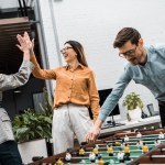 Business colleagues playing table football together in office