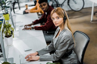office işyerinde kameraya bakarak kulaklıklar çok ırklı çağrı merkezi operatörleri
