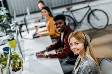 seçici odak çalışma office çok ırklı gülümseyen çağrı merkezi operatörleri
