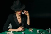 atraktivní dívka v bundě a čepici držel sklenku whisky a poker žetony v kasinu u stolu