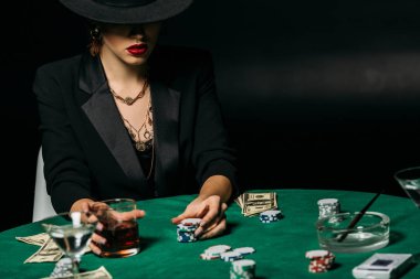çekici kumarbaz ceketi ve casino poker masasında bardak viski holding şapkası