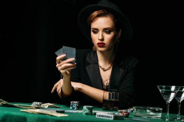 çekici kız ceket ve iskambil poker ve casino kart bakarak şapka