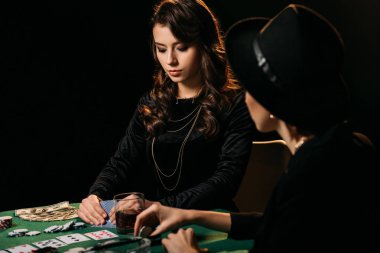 Tablo casino poker oynayan siyah giysili güzel kadınlar