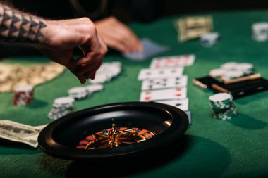 kadın ve dövmeli adam Casino rulet masasında oynarken görüntü kırpılmış