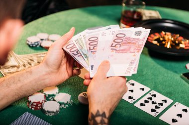 dövmeli adamın casino poker masasında euro banknot holding resim kırpılmış