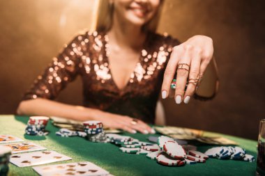 görüntü gülümseyen kız masada casino poker oynamaya kırpılmış