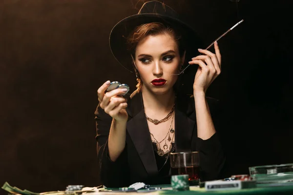 Привлекательная Девушка Куртке Шляпе Курить Сигарету Покерным Столом Казино Смотреть — стоковое фото