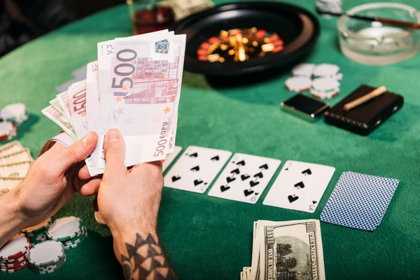 Imagem Cortada Homem Tatuado Segurando Dinheiro Mesa Poker Cassino — Fotografia de Stock