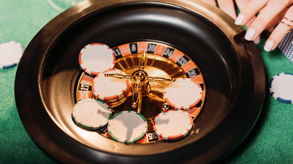 cropped image of girl playing roulette in casino