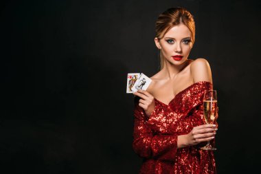 joker ve siyah, izole kalp kartları kameraya bakarak kraliçesi tutan kırmızı parlak elbiseli çekici kız