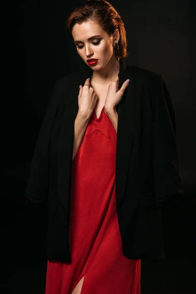 Приваблива Дівчина Червоній Сукні Чорна Куртка Дивиться Вниз Ізольовано Чорному — Безкоштовне стокове фото