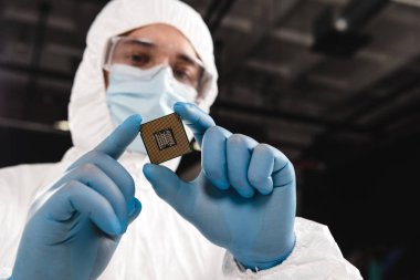 selective focus of microchip in hands of scientist wearing latex gloves  clipart