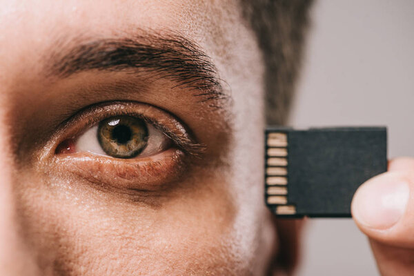 cropped view of man holding microchip near head 