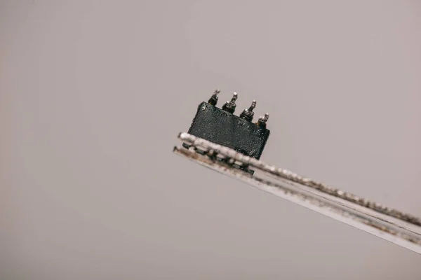 Nahaufnahme Einer Metallischen Pinzette Mit Kleinem Mikrochip Auf Grauem Hintergrund — Stockfoto