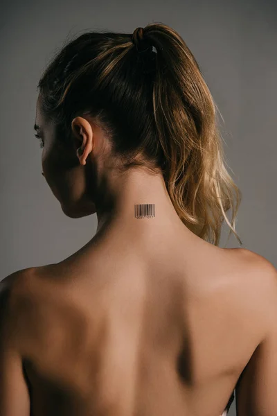 back view of blonde woman with barcode on neck on grey background