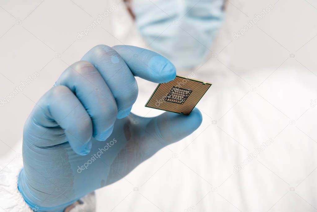 selective focus of microprocessor in hand of scientist wearing latex glove isolated on grey 