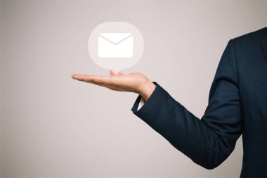 partial view of businessman in suit gesturing and presenting email icon isolated on grey clipart