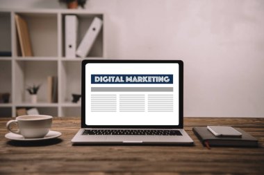 dijital pazarlama, smartphone ve ahşap masa üzerinde kahve ile dizüstü bilgisayar