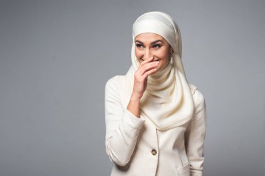 güzel genç gülüyor ve uzağa bakarak Müslüman kadın gri izole