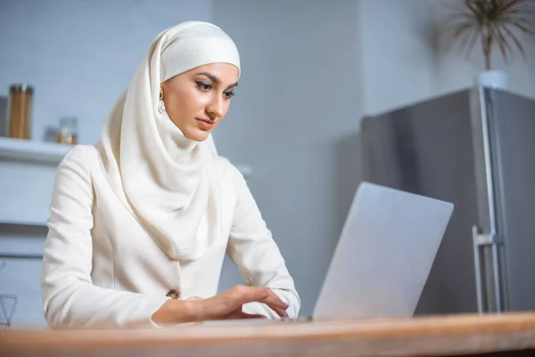 美丽的年轻穆斯林妇女使用笔记本电脑在家里 — 图库照片
