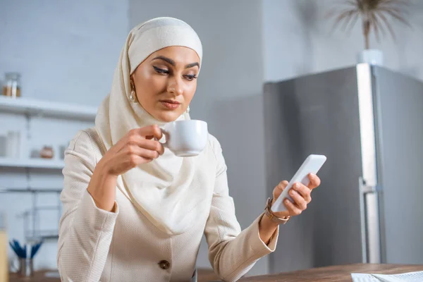 Young Muslim Woman Holding Cup Coffee Using Smartphone Home — Stock Photo, Image