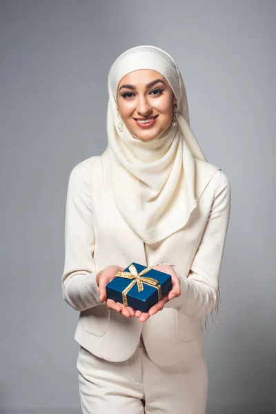Счастливая Молодая Мусульманка Держит Подарочную Коробку Улыбается Камеру Изолированную Сером — стоковое фото