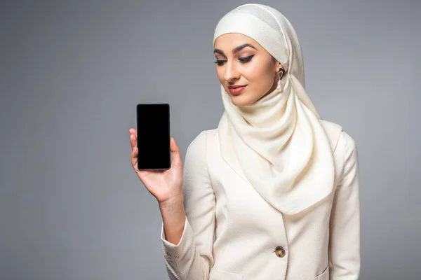 Hermosa Joven Musulmana Sonriente Sosteniendo Teléfono Inteligente Con Pantalla Blanco — Foto de Stock