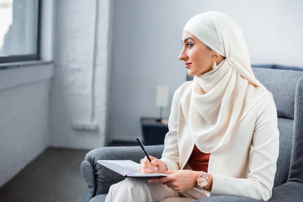 Schöne Junge Muslimische Frau Sitzt Stuhl Mit Notizblock Und Schaut — Stockfoto